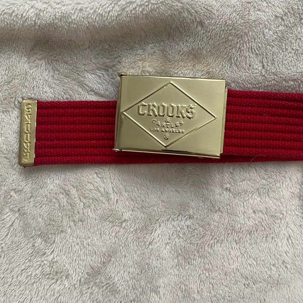 Crooks gold buckle web red belt. Fits up to size 34.